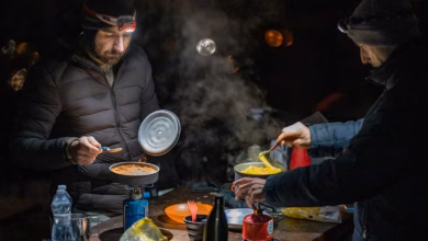 10 Koch-Tools für Motorrad-Camper » 6 Zwei Motorradfahrer kochen im Dunklen draußen
